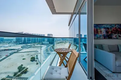 a balcony with a table and a view of a city at Stylish 1BR Apartment at Orchid Residence, Al Barsha South by Deluxe Holiday Homes in Dubai