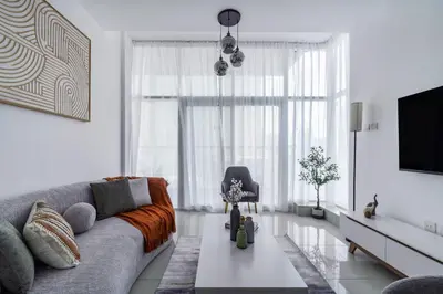 a living room with a couch and a tv at ShoresInn - Chic Waterfront Living in Dubai Marina in Dubai