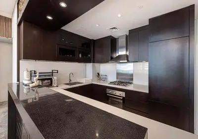a kitchen with dark brown cabinets and a counter top at Burj Khalifa View! 2 Bedroom Luxe Apartment with 4 minute walk to Dubai Mall! Pool and Sauna Access! in Dubai