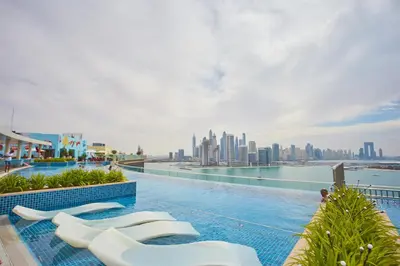 a swimming pool with lounge chairs on the roof of a building at Hight-floor Studio Atlantis view in Dubai