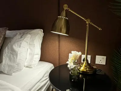 a lamp sitting on a table next to a bed at Hight-floor Studio Atlantis view in Dubai