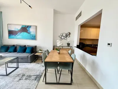 a living room with a table and a couch at Sparkle Tower Panoramic Marina View 1BR in Dubai