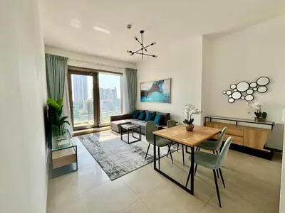 a living room with a table and a couch at Sparkle Tower Panoramic Marina View 1BR in Dubai