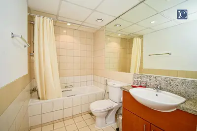 a bathroom with a sink and a toilet and a bath tub at Luxury Escapes - Spacious 1BR with Pool view - Ghozlan 2 The Greens in Dubai