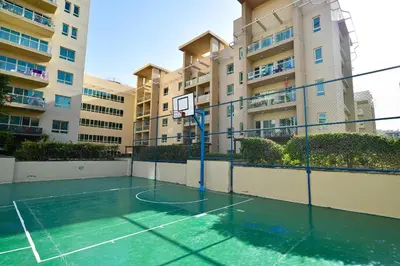 a basketball court in front of a building at Luxury Escapes - Spacious 1BR with Pool view - Ghozlan 2 The Greens in Dubai