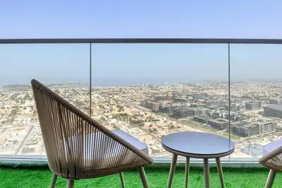 a table and chairs in front of a large window at 5 Star Apartment with Burj View Infinity Pool and Gym Spa in Dubai
