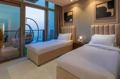 two beds in a room with a balcony at 5 Star Apartment with Burj View Infinity Pool and Gym Spa in Dubai
