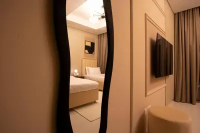 a reflection of a bedroom with a bed in a mirror at 5 Star Apartment with Burj View Infinity Pool and Gym Spa in Dubai