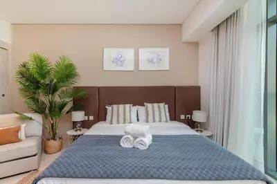 a bedroom with a large bed with towels on it at Modern and Cozy Studio at Seven Palm Prime Location in Dubai