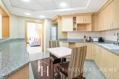 a kitchen with a table and chairs and a sink at LUX The Shoreline Palm Island Penthouse in Dubai