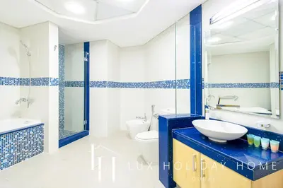 a blue and white bathroom with a sink and a toilet at LUX The Shoreline Palm Island Penthouse in Dubai