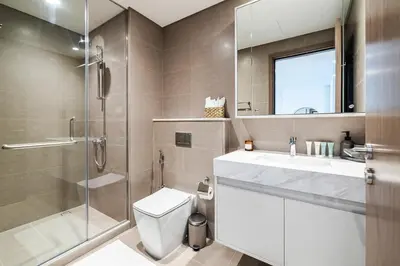 a bathroom with a shower and a toilet and a sink at 1BR Burj Royale Near Dubai Mall Downtown in Dubai