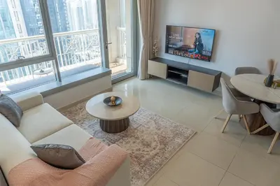 a living room with a couch and a tv at Downtown Gem, Full Burj Khalifa & Dubai Fountain Views, Luxury Amenities in Dubai