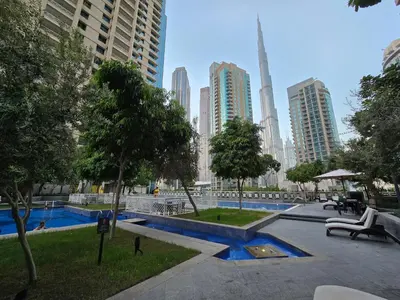 a park in a city with tall buildings at Downtown Gem, Full Burj Khalifa & Dubai Fountain Views, Luxury Amenities in Dubai