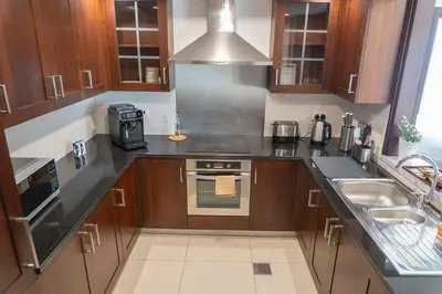 a kitchen with a sink and a stove top oven at Downtown Gem, Full Burj Khalifa & Dubai Fountain Views, Luxury Amenities in Dubai