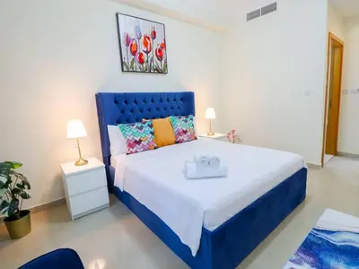 a bedroom with a large bed with a blue headboard at Vibrant 1 Bedroom at Barasti-Dubai Marina in Dubai