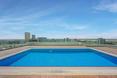 a swimming pool on the roof of a building at Comfortable Studio With Dubailand Vibes in Dubai