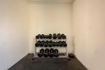 a room with a rack of dumbbells on the wall at Comfortable Studio With Dubailand Vibes in Dubai