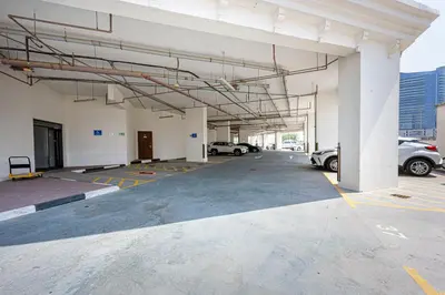 an empty parking lot with cars parked in it at Comfortable Studio With Dubailand Vibes in Dubai
