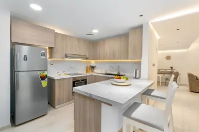 a kitchen with a refrigerator and a table and chairs at Vacay Lettings - Spacious 3 Bedroom at JBR walk in Dubai