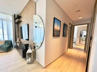 a living room with a mirror on the wall at Luxury 2BR w Waterfront View & Smart Controls by Vibel in Dubai