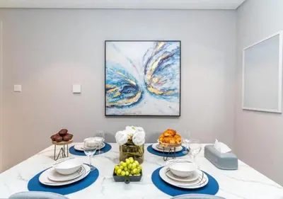 a dining room with a table with a painting on the wall at Classy 1BR in Midtown Access All Dubai Spots by Vibel in Dubai