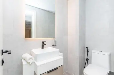 a white bathroom with a sink and a toilet at Classy 1BR Midtown Stay Near Miracle Garden by Vibel in Dubai