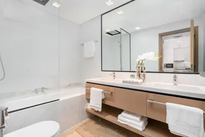 a bathroom with a sink and a tub and a mirror at Stylish 1BR w City Views Palace Creek Harbour by Vibel in Dubai