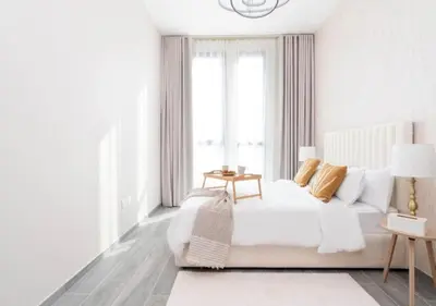 a white bedroom with a bed and a window at Cozy 2BR Near Dubai Spots Midtown Dubai Access by Vibel in Dubai