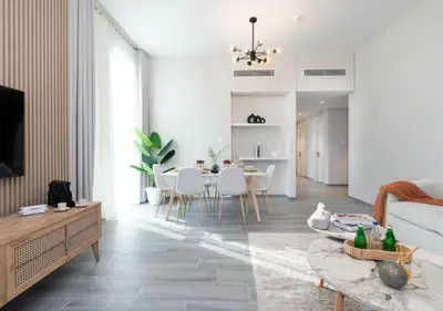 a living room with a couch and a table at Cozy 2BR Near Dubai Spots Midtown Dubai Access by Vibel in Dubai