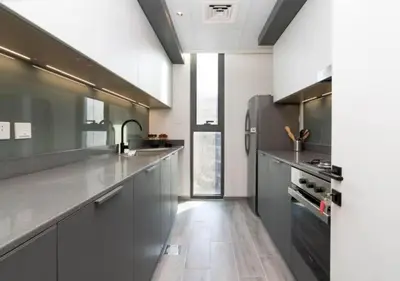 a kitchen with stainless steel appliances and gray cabinets at Cozy 2BR Near Dubai Spots Midtown Dubai Access by Vibel in Dubai