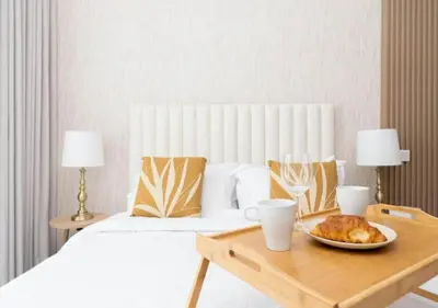 a bedroom with a bed and a table with a plate of food at Cozy 2BR Near Dubai Spots Midtown Dubai Access by Vibel in Dubai