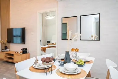 a dining room with a table and chairs and a bedroom at Cozy 1BR Midtown 20 Mins to Mall of Emirates by Vibel in Dubai