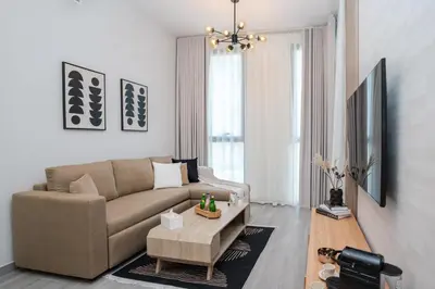 a living room with a couch and a coffee table at Cozy 1BR Midtown 20 Mins to Mall of Emirates by Vibel in Dubai