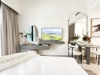 a bedroom with a bed and a tv on a wall at Trophy Blissful Bend Studio in Meydan with Pool Views in Dubai