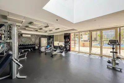 a gym with treadmills and machines in a room at 1BR The Greens Courtyard View in Dubai