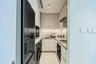 a kitchen with white cabinets and stainless steel appliances at Luxury at JBR Jumeirah Gate Tower 1 1 Bed in Dubai