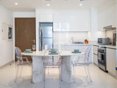 a kitchen with a table and chairs and a refrigerator at Dubai Hills Elegant 1-Bed with Terrace in Dubai