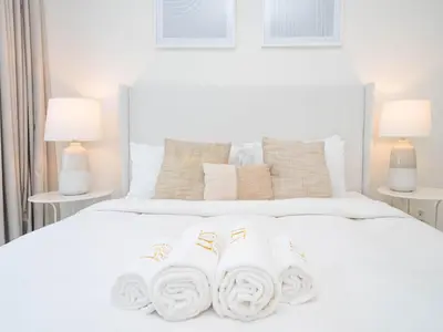 a bedroom with a white bed with two towels on it at Dubai Hills Elegant 1-Bed with Terrace in Dubai