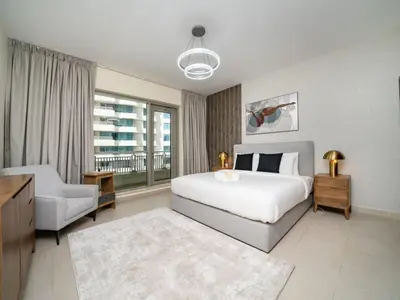 a bedroom with a bed and a chair and a window at Downtown 1 Bed - Burj Khalifa Balcony View in Dubai