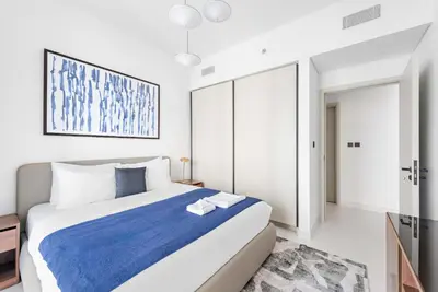 a bedroom with a large bed with a blue blanket at Silkhaus Marina View 1BDR Private Beach Access in Dubai