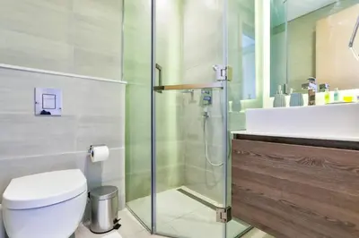 a bathroom with a shower and a toilet and a sink at 2 BR with Maid's Next to Dubai Mall Mada Residences in Dubai