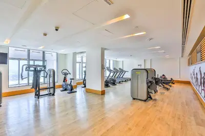 an empty gym with treadmills and exercise machines at 2 BR with Maid's Next to Dubai Mall Mada Residences in Dubai