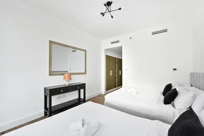 a bedroom with two beds and a mirror at Prime Downtown Burj Khalifa I Sleeps 8 in Dubai