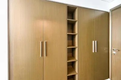 a closet with wooden doors and shelves at Prime Downtown Burj Khalifa I Sleeps 8 in Dubai