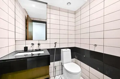 a bathroom with a toilet and a sink and a mirror at Prime Downtown Burj Khalifa I Sleeps 8 in Dubai