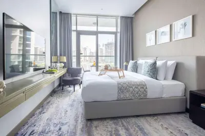 a hotel room with a large bed and a desk at Frank Porter - Damac Maison Prive B in Dubai