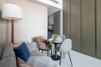 a living room with a couch and a table with chairs at Frank Porter - Damac Maison Prive B in Dubai