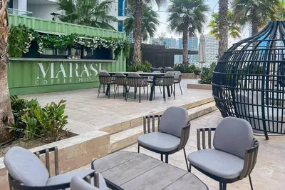 a group of chairs and tables in a patio at Frank Porter - Damac Maison Prive B in Dubai