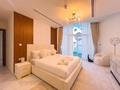 a bedroom with a large white bed and a chair at Millennium Binghatti Residence 2BR Burj Khalifa and Lake in Dubai